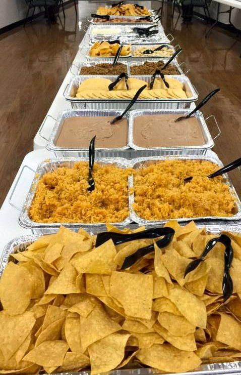 Table set with Mexican food: chips, rice, beans, and other dishes.