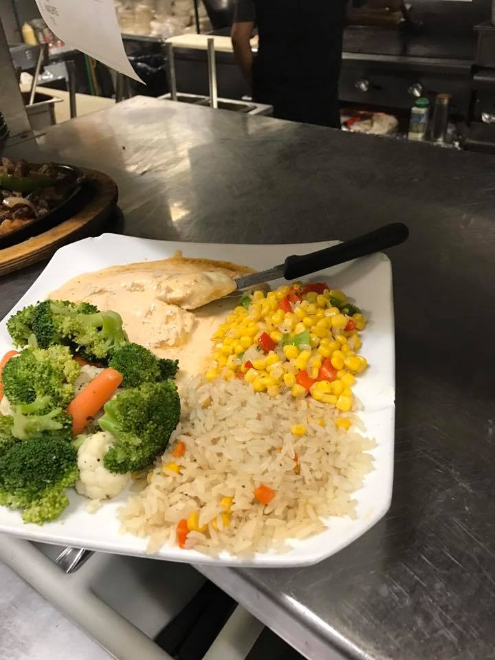 Plate with chicken, rice, corn, and broccoli.