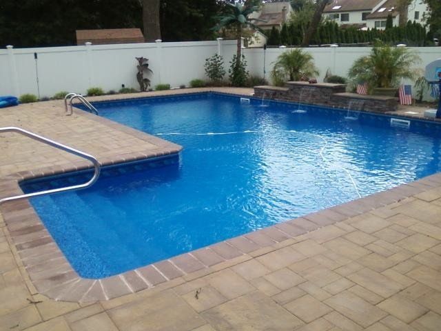 a large swimming pool with a waterfall in the backyard
