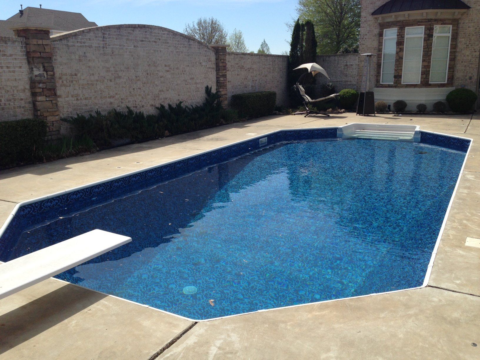 a large swimming pool with a diving board in the middle