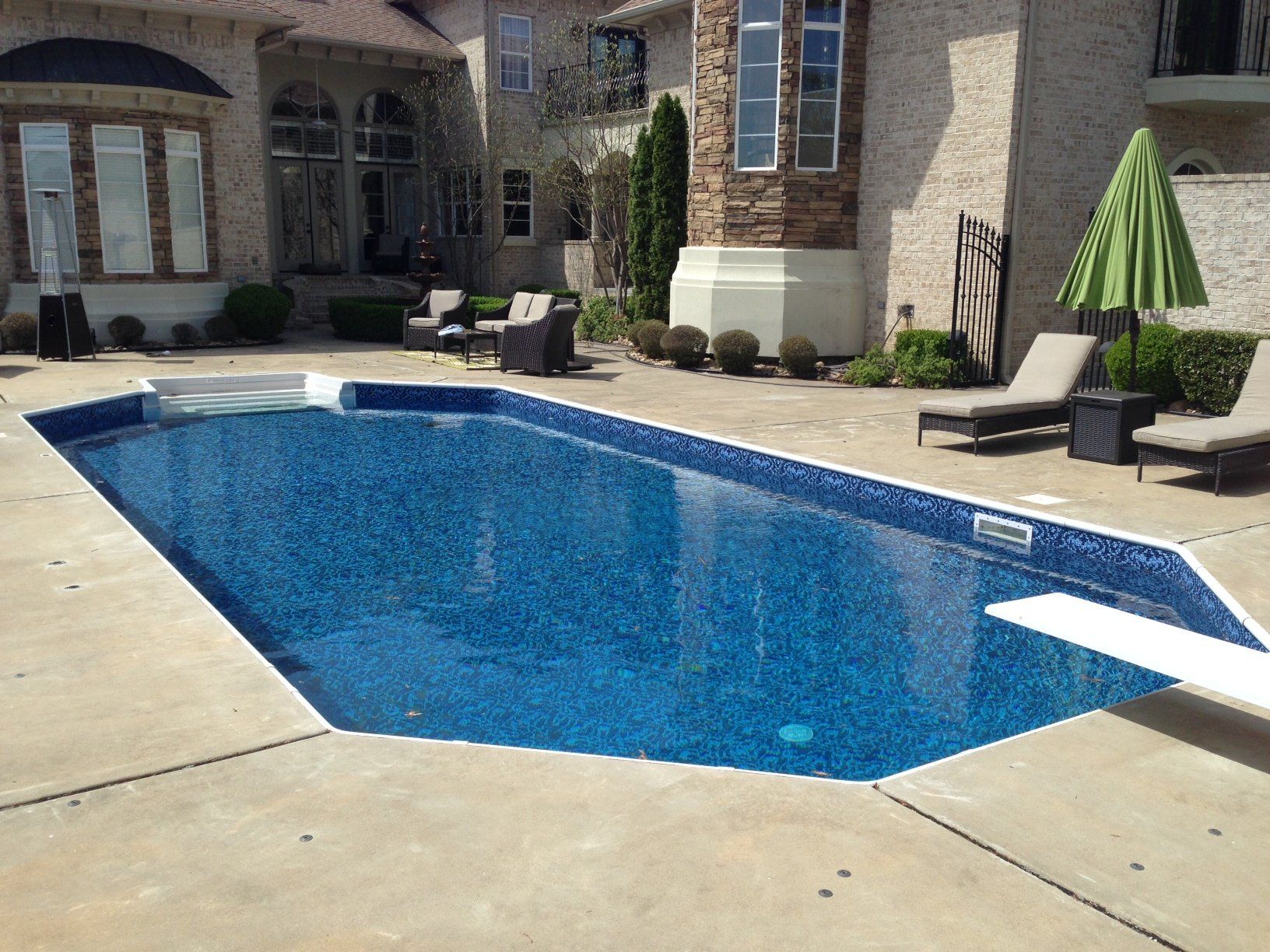 a large swimming pool in front of a large house