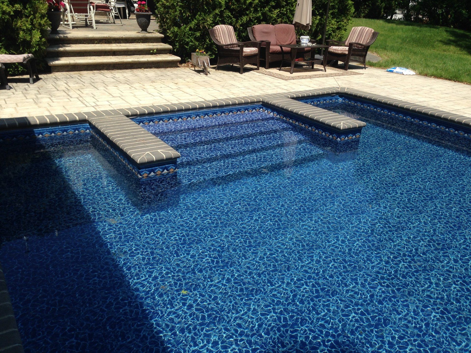 a swimming pool with a patio in the background