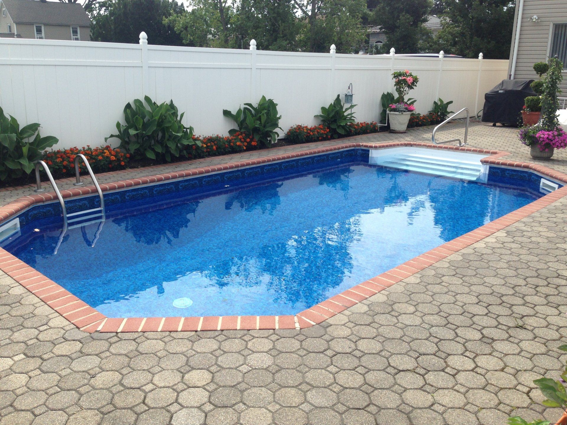 a swimming pool with a white fence surrounding it