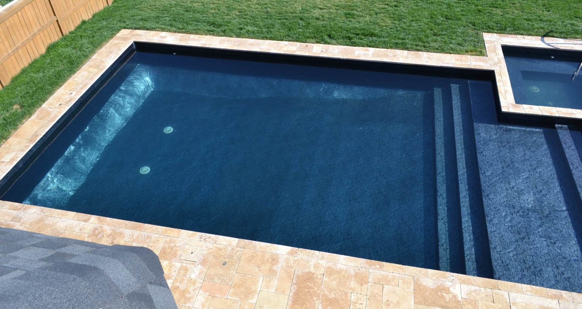 a swimming pool with a fence in the background