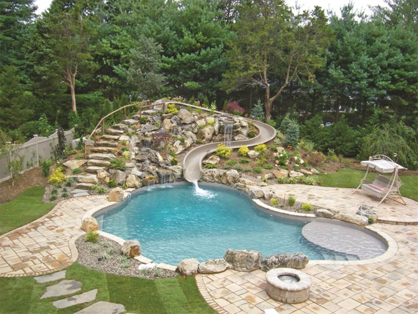 a large swimming pool with a water slide in the backyard