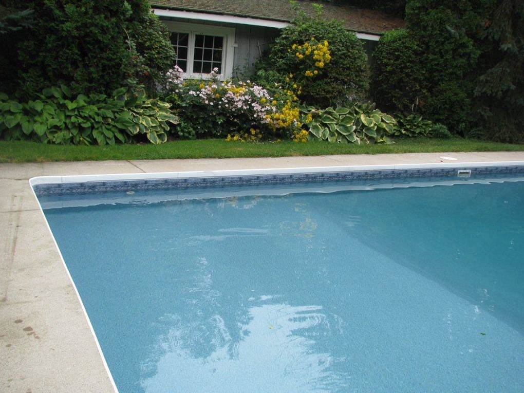 a swimming pool with a house in the background