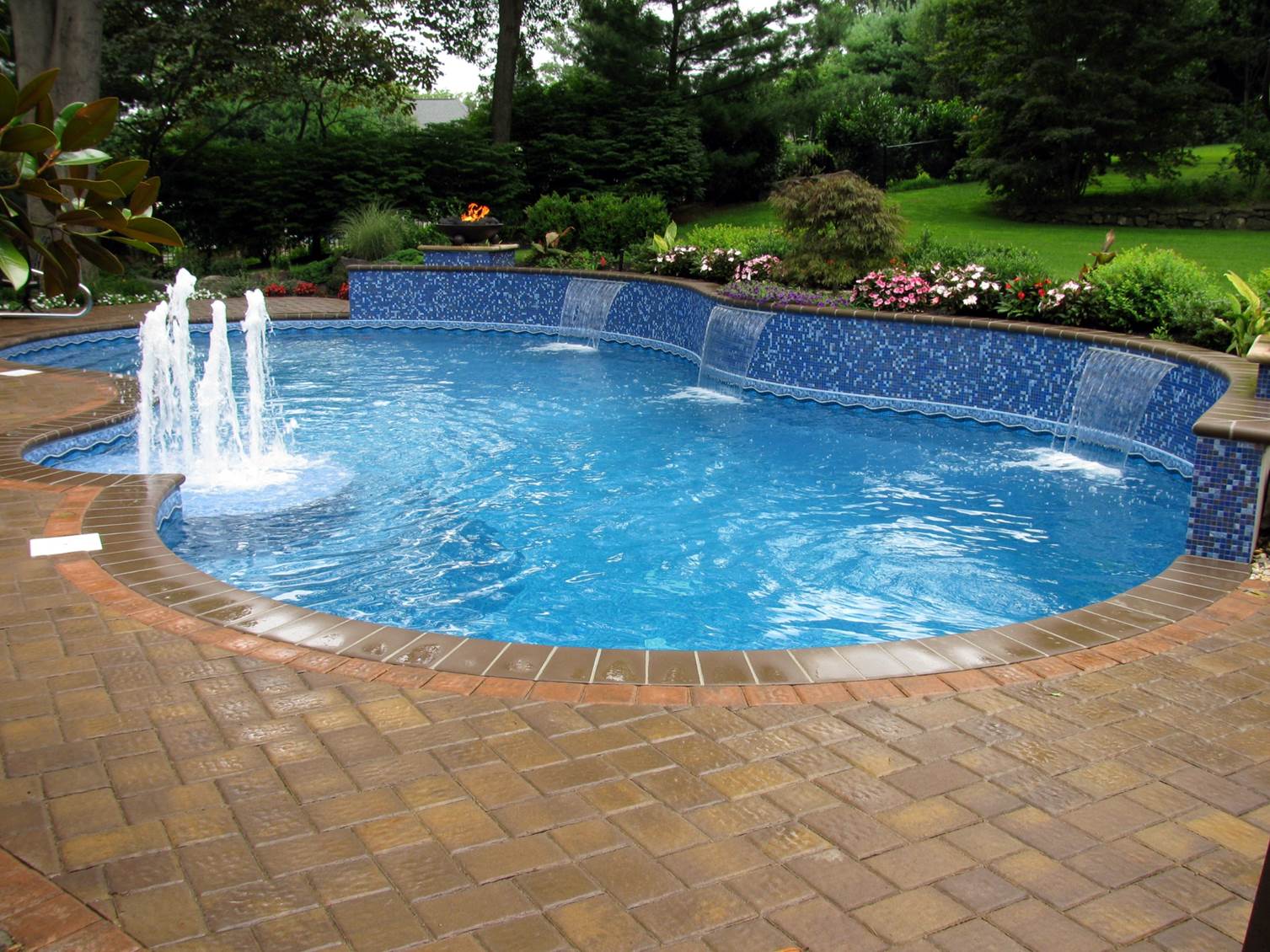 a swimming pool with a fountain in the middle of it