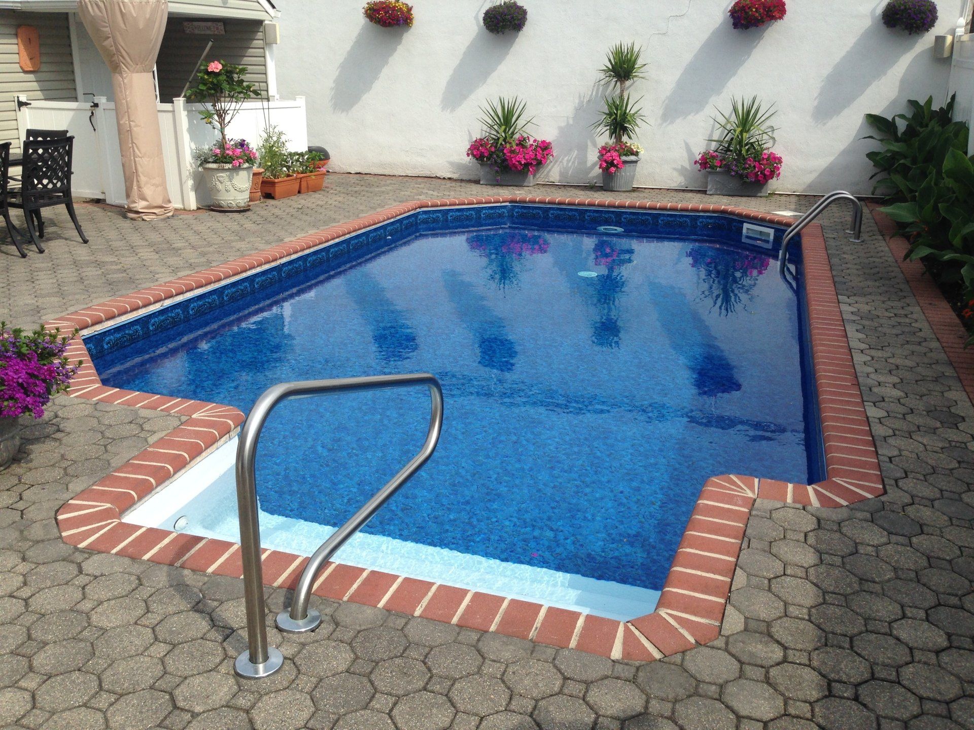 a swimming pool surrounded by potted plants and flowers