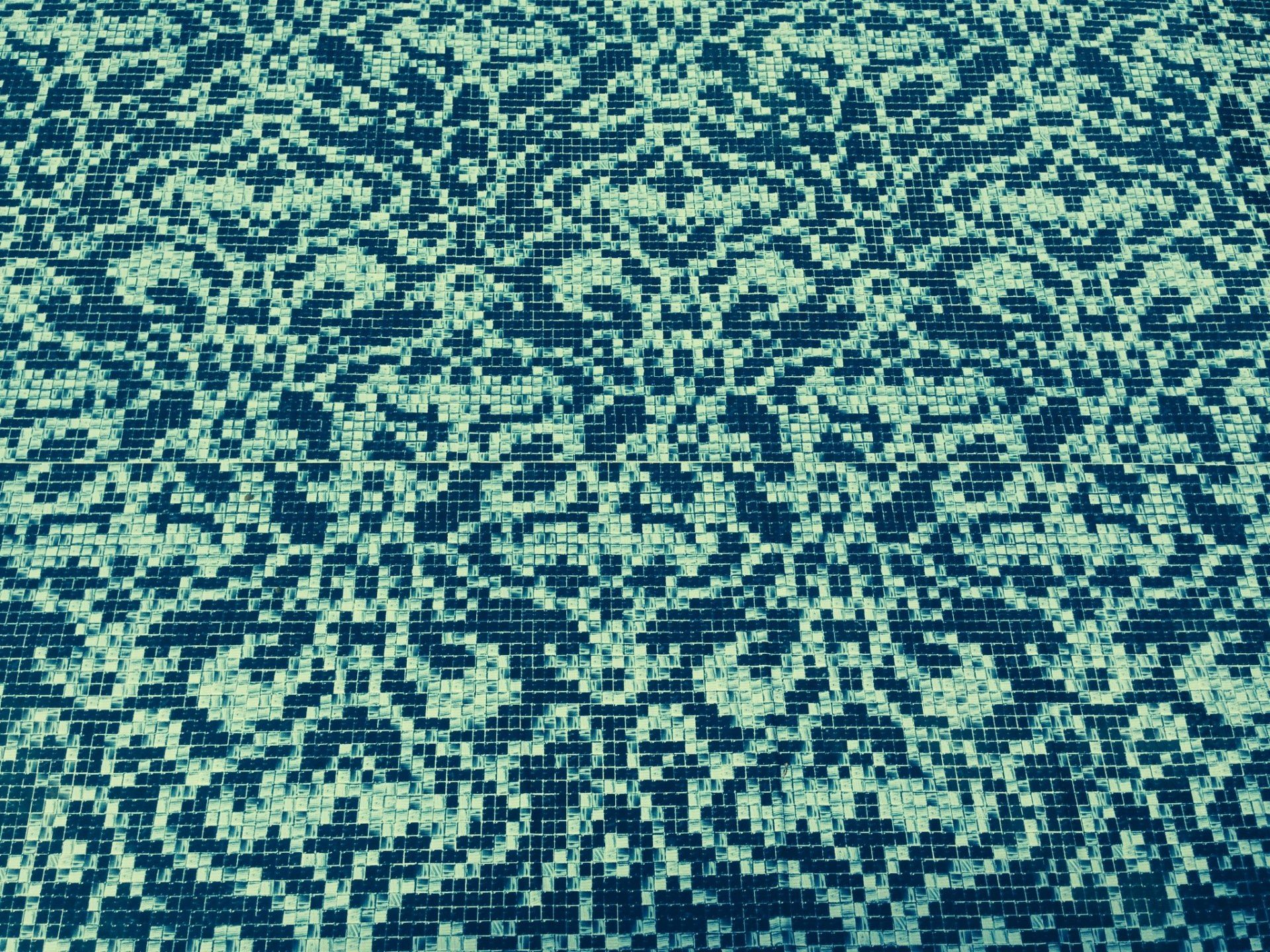 a swimming pool with a blue and green mosaic pattern