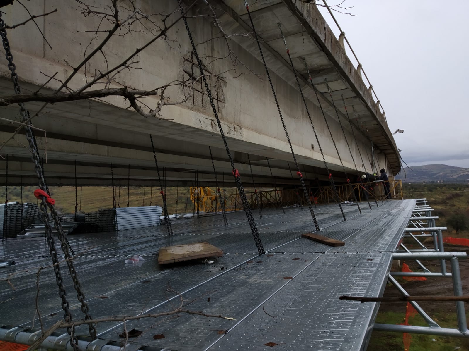 Un ponte che viene costruito con molte catene appese ad esso