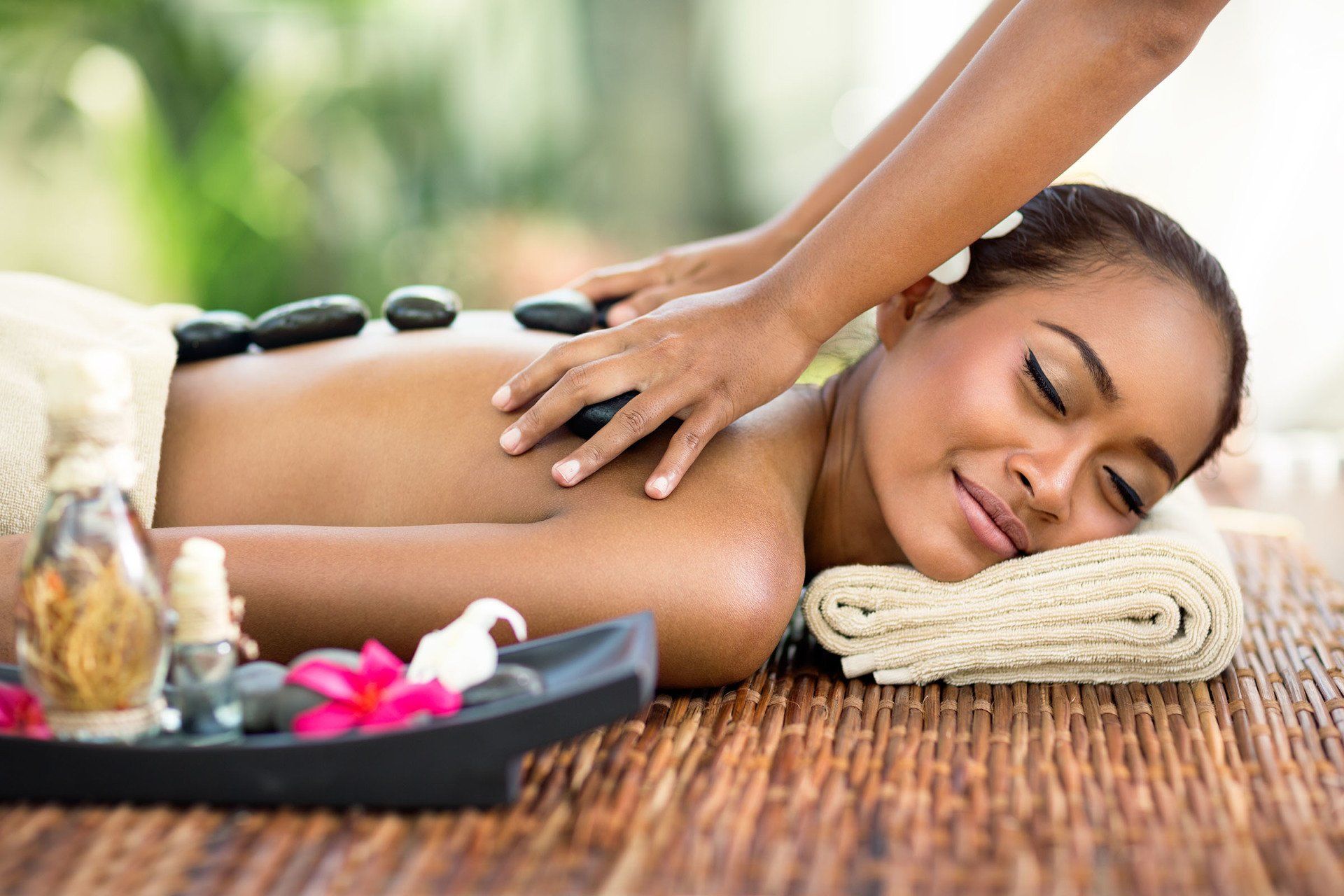 A woman is getting a hot stone massage at a spa.