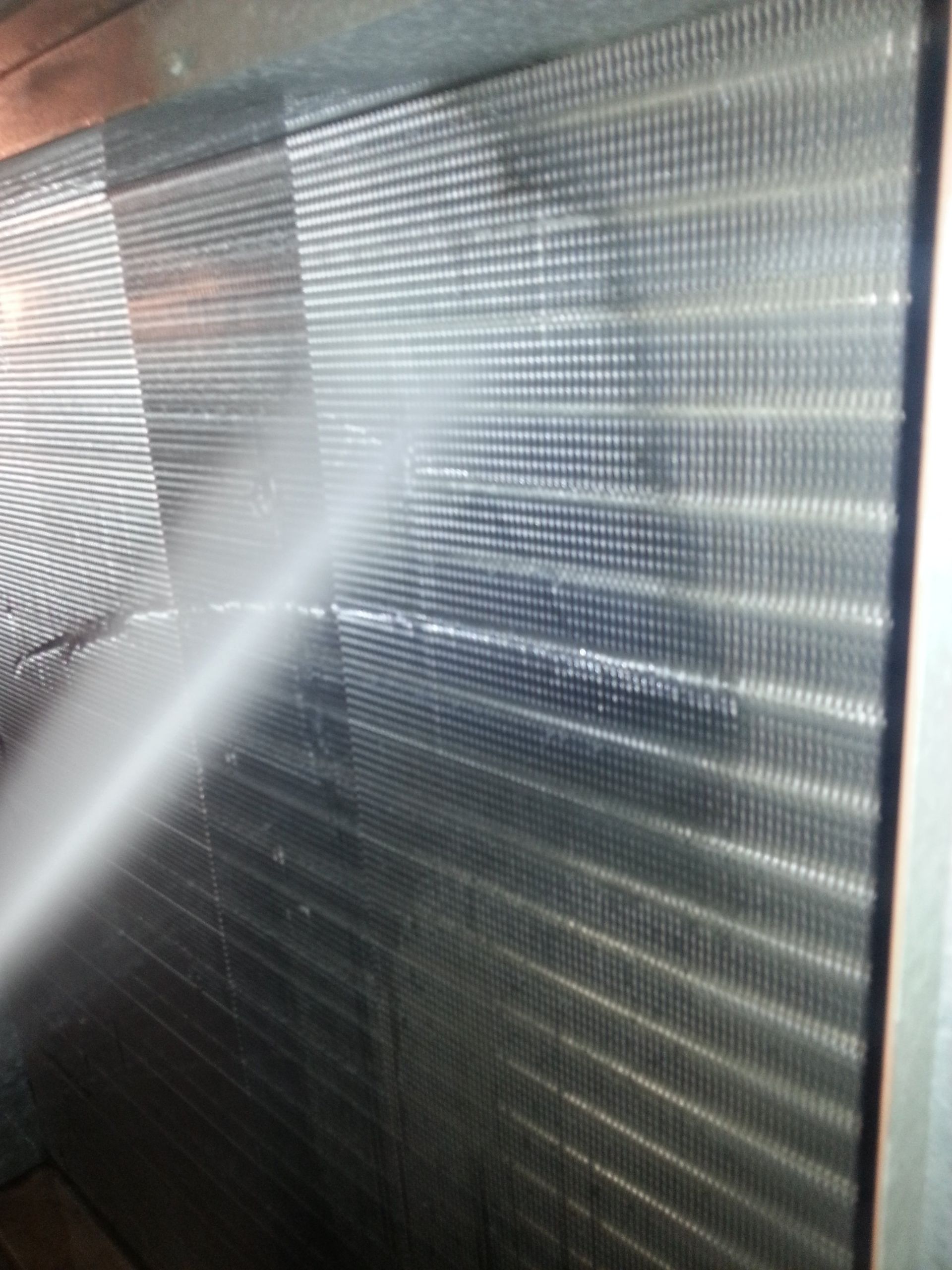 a person is cleaning an air conditioner with a high pressure washer .