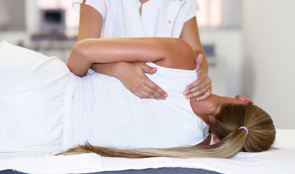 Female Physiotherapist Giving Shoulder Massage — Female Physiotherapist Giving Shoulder Massage —