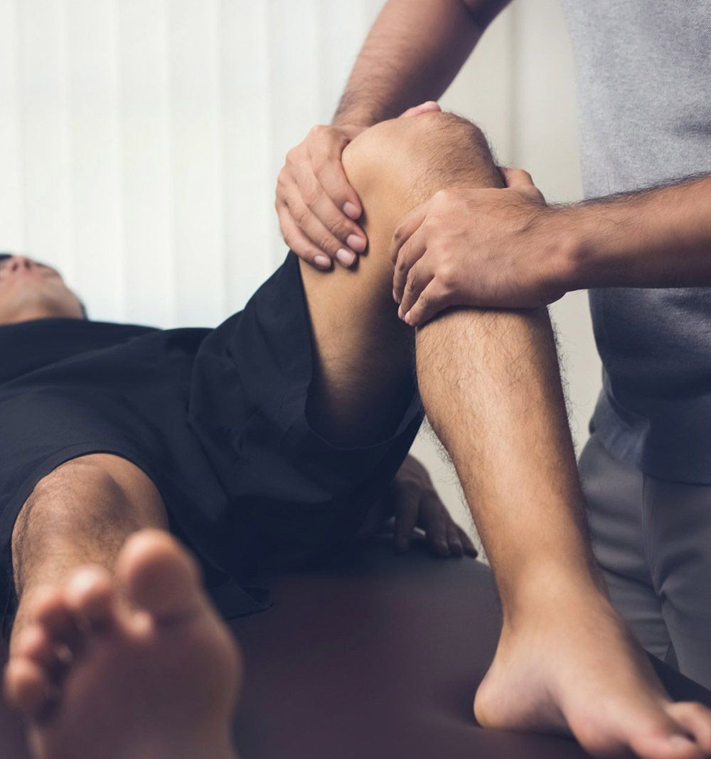 Male Therapist Massaging Knee — Massage in Port Stephens, NSW Male Therapist Massaging Knee — Massage in Port Stephens, NSW