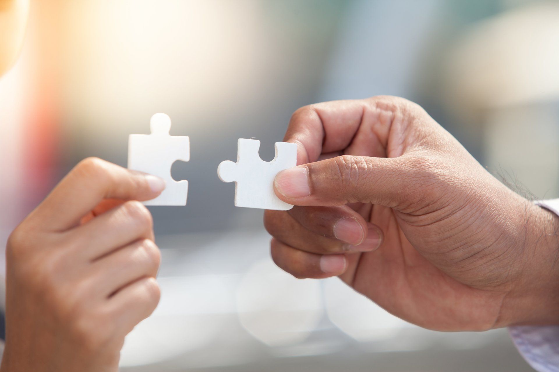 Un homme et une femme tiennent deux pièces de puzzle dans leurs mains.