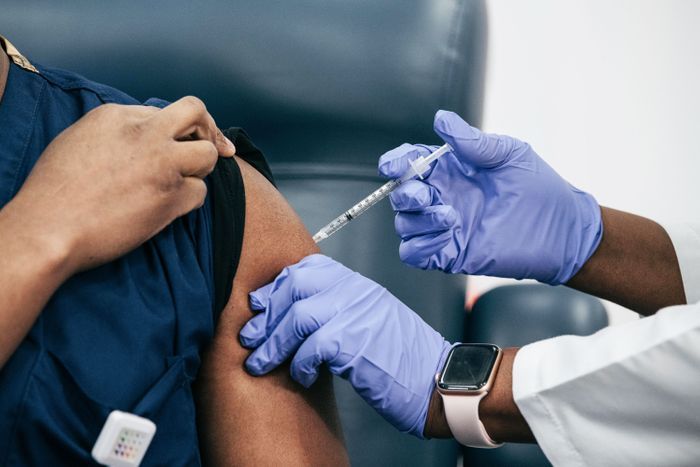 A person is getting a vaccine in their arm.