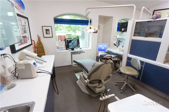 Dental office with a chair, window, equipment, and monitors.