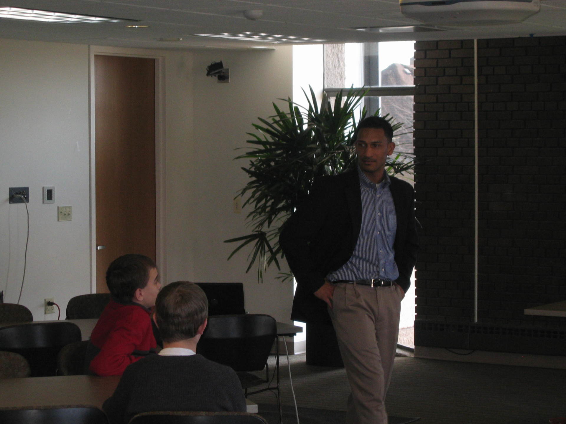 Male speaker standing  and speaking with students at previous Positive Images Leadership Teen Summit meeting in Milwaukee