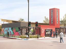 Steelcraft food hall rendering: Red buildings with mural, sign tower, people on sidewalk, sunny outdoor setting.