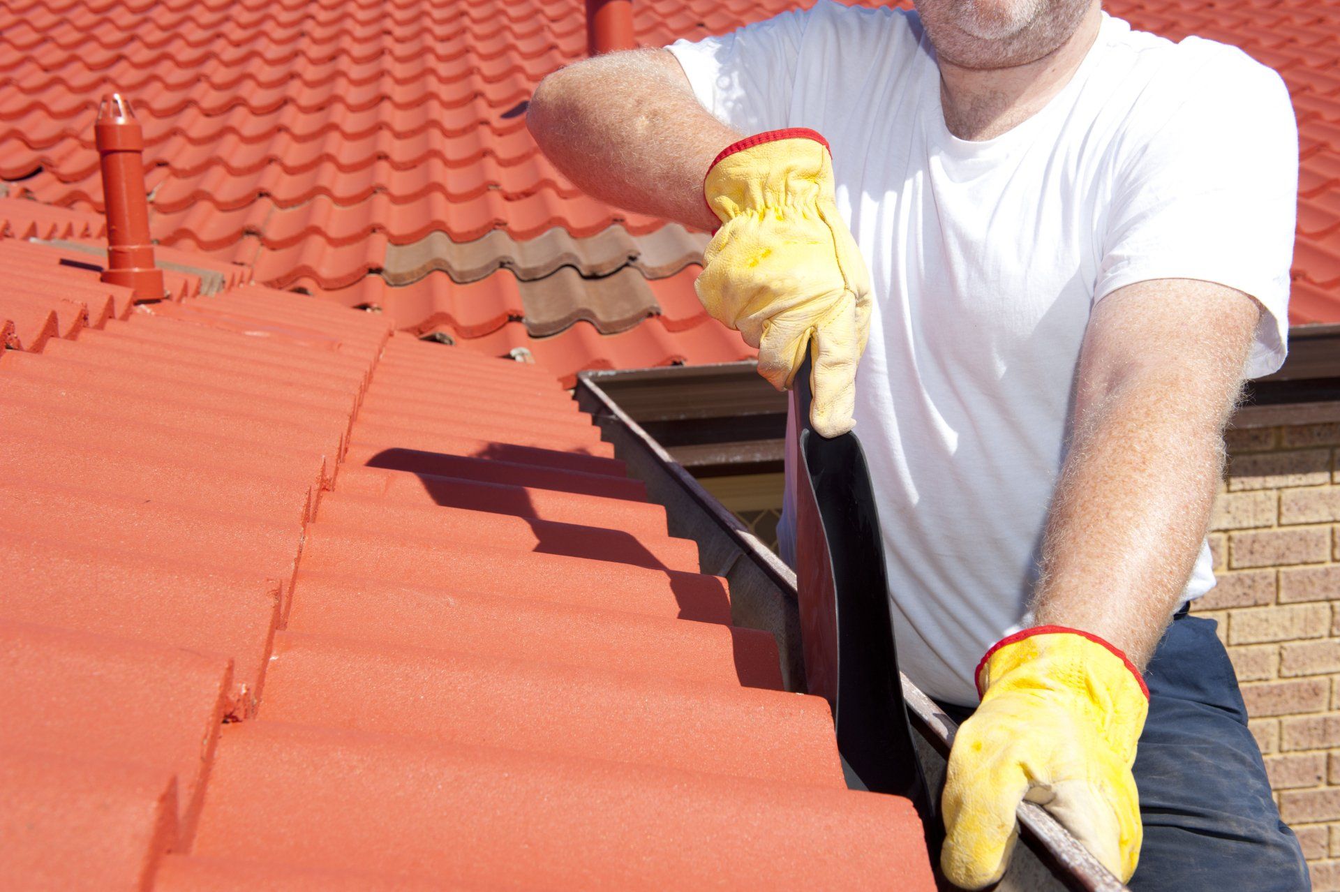 Worker Cleaning Gutter — Gutter Cleaning in Central Coast, NSW Worker Cleaning Gutter — Gutter Cleaning in Central Coast, NSW