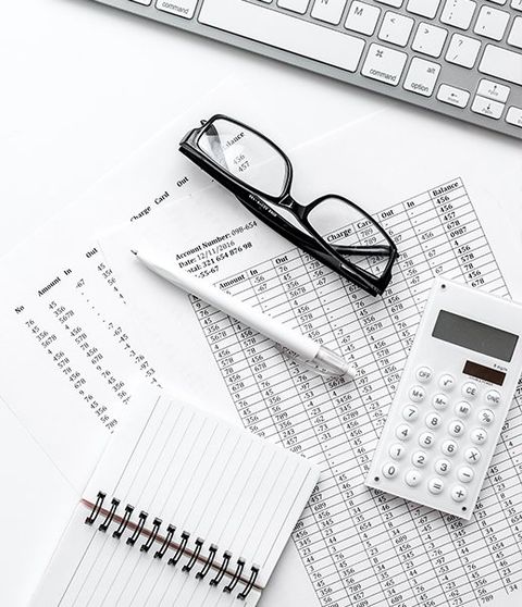 Business report preparing with calculator and glasses