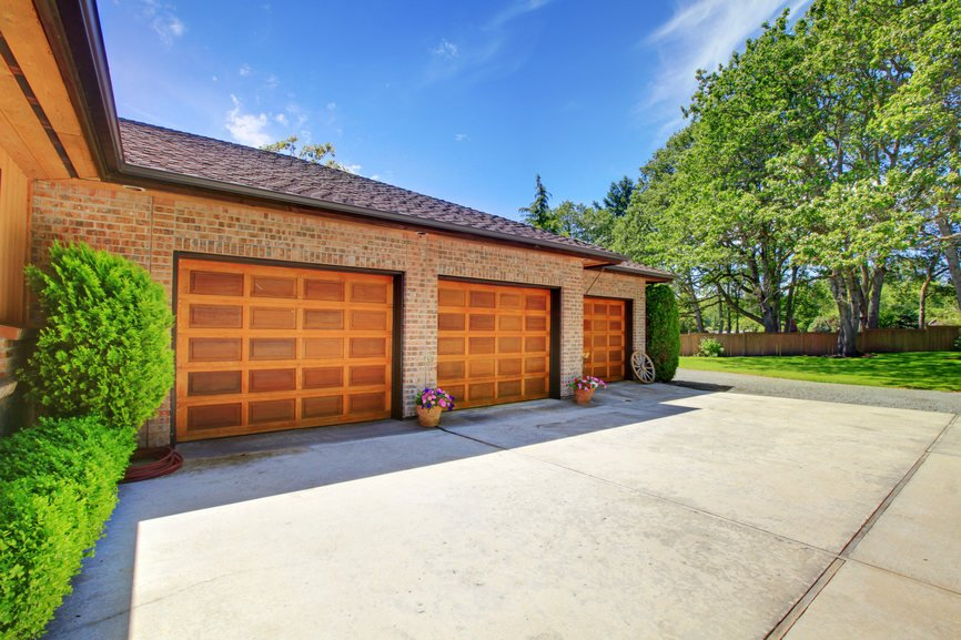 A large house with three garage doors and a driveway.