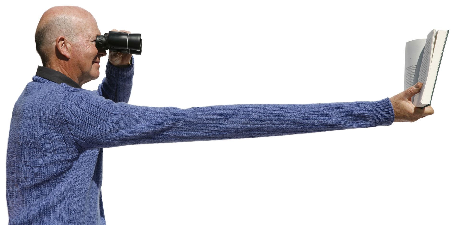 Man looking through binoculars and holding a book on exaggerated outstretched arm to demonstrate farsightedness