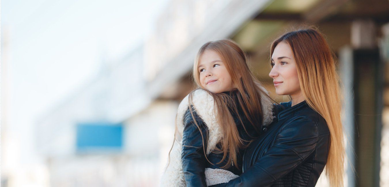 A woman is holding a little girl in her arms.