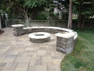 Rounded Fire Pit With Stone Curve Bench — Landscaping in Shelby Township, MI Rounded Fire Pit With Stone Curve Bench — Landscaping in Shelby Township, MI