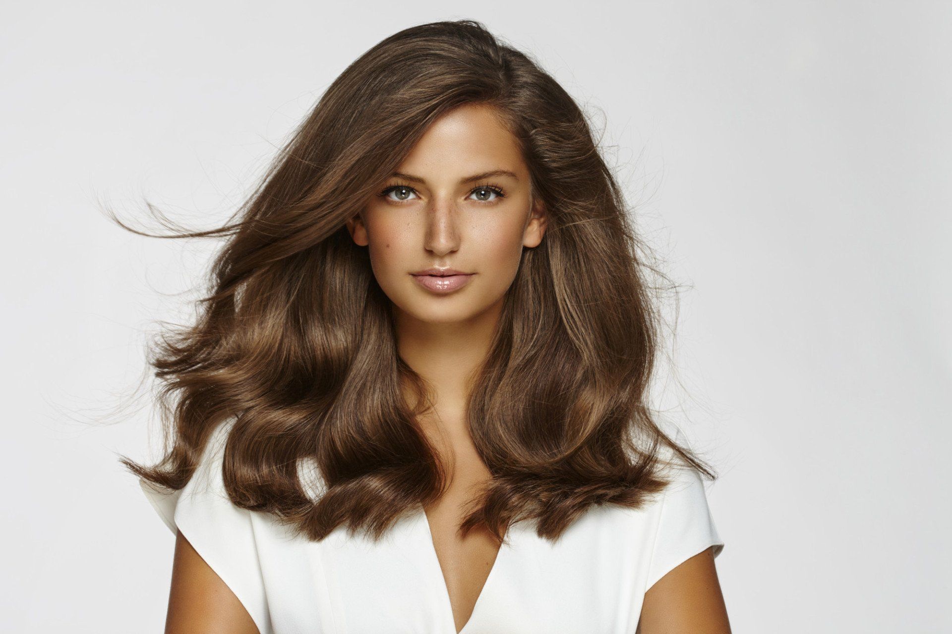 model with dark hair tanned wearing white cotton top