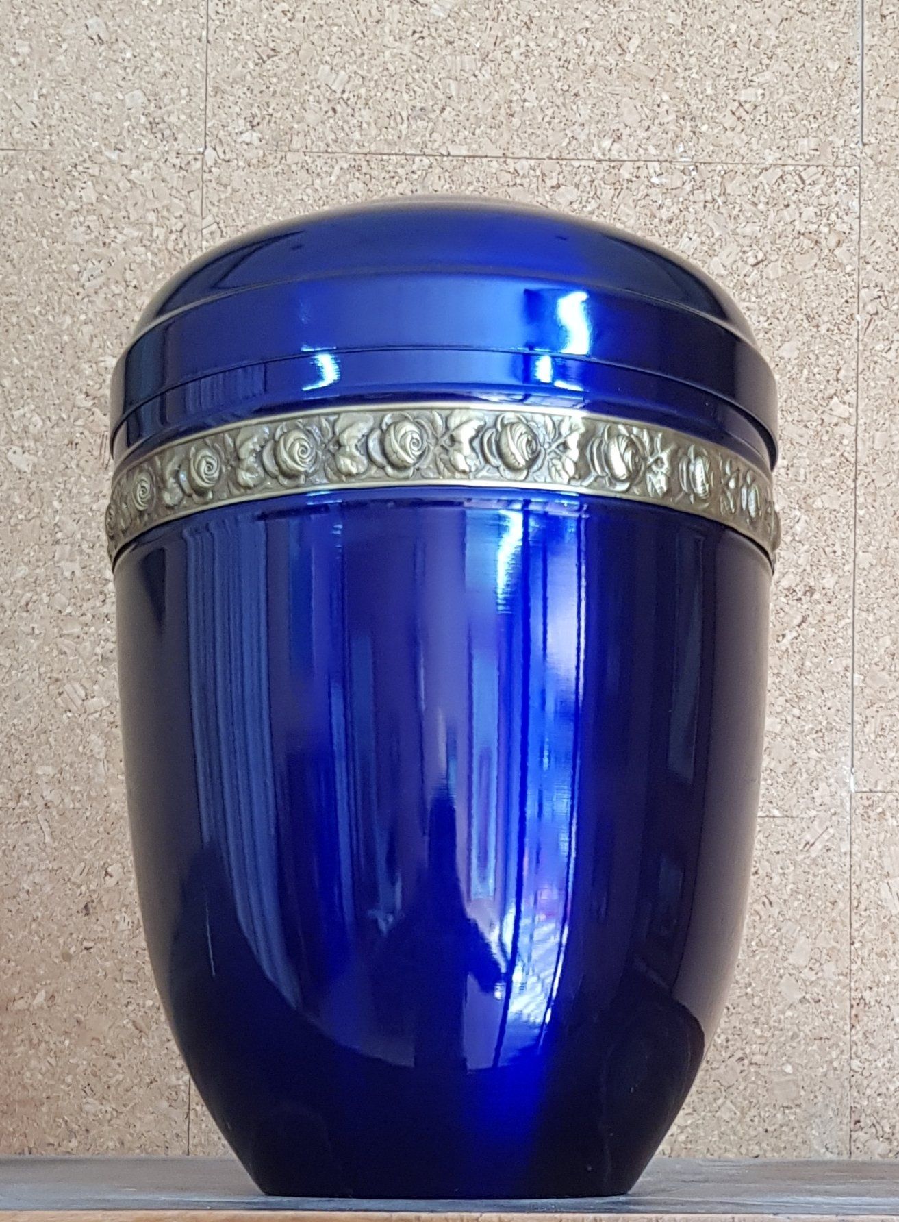 Urna cineraria blu con fascia decorativa.