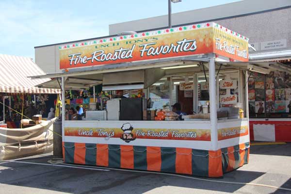 A food stand that says fire roasted favorites on it