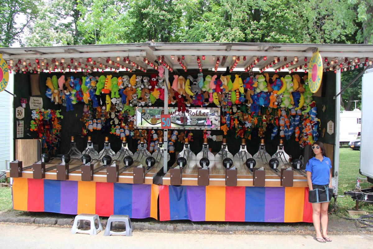 A woman stands in front of a carnival display
