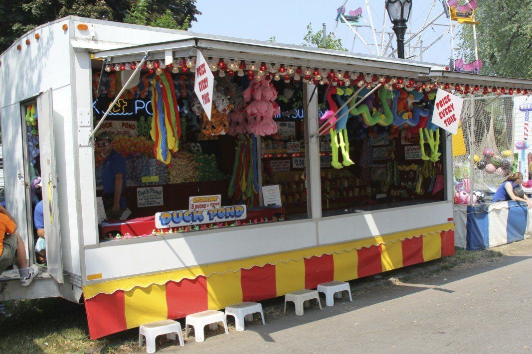 A booth at a carnival has a sign that says bugs paws