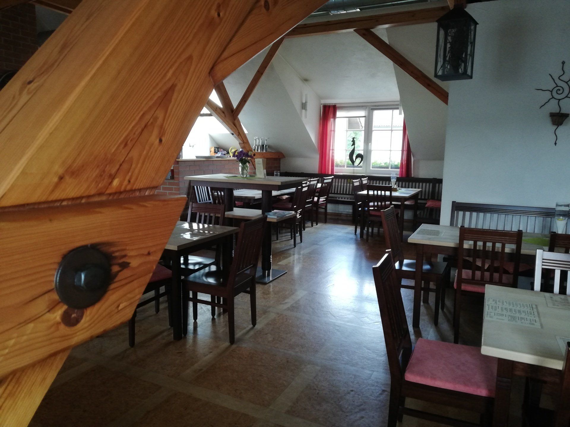 Ein Restaurant mit Tischen und Stühlen und einer Holztreppe