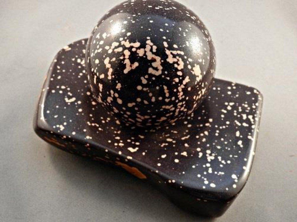 Black round stone with a flat base