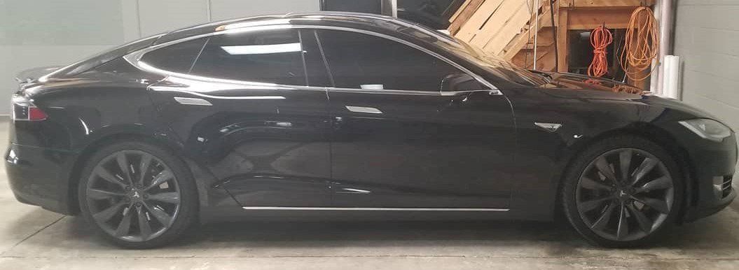 Black Tesla Model S car parked indoors.