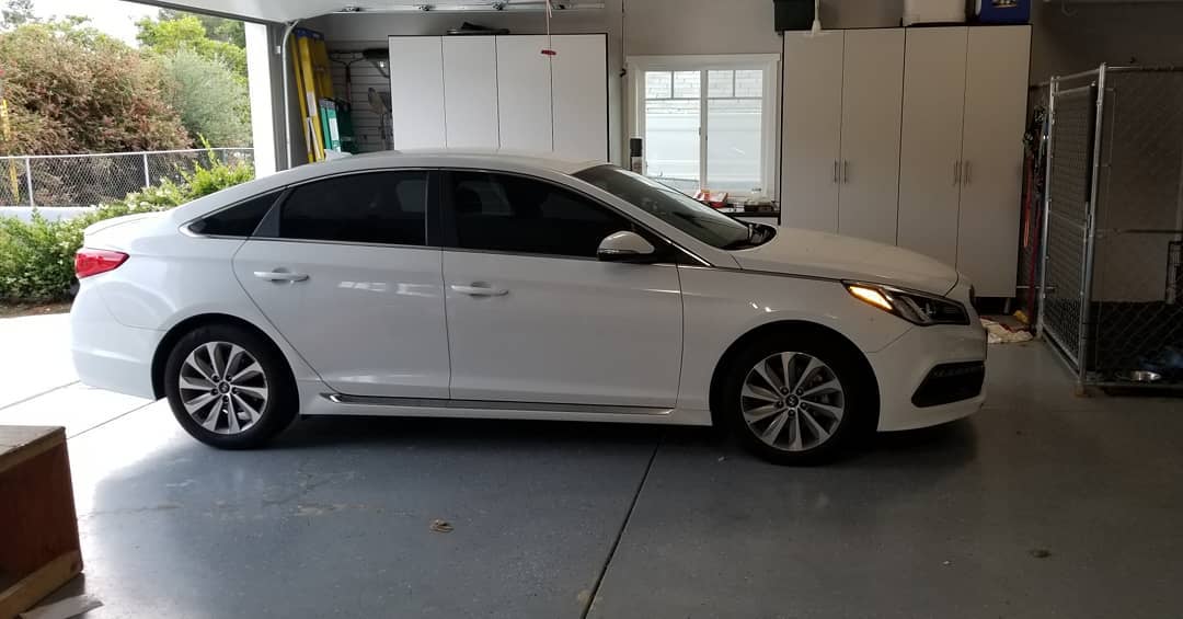 White sedan parked in a garage.