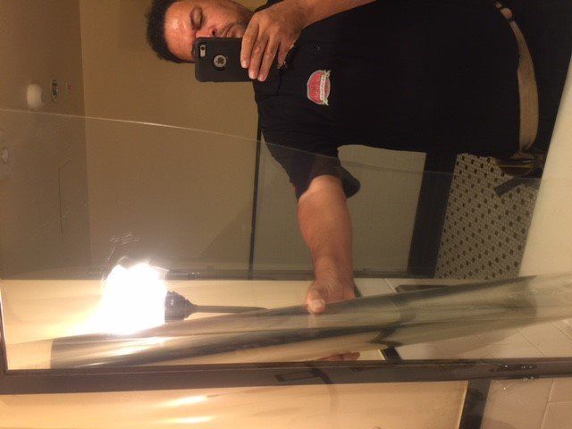 Person holding a phone taking a mirror selfie. Reflected light flares on a pane of glass.