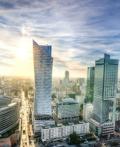 Warsaw skyline with modern skyscrapers under a bright sky.
