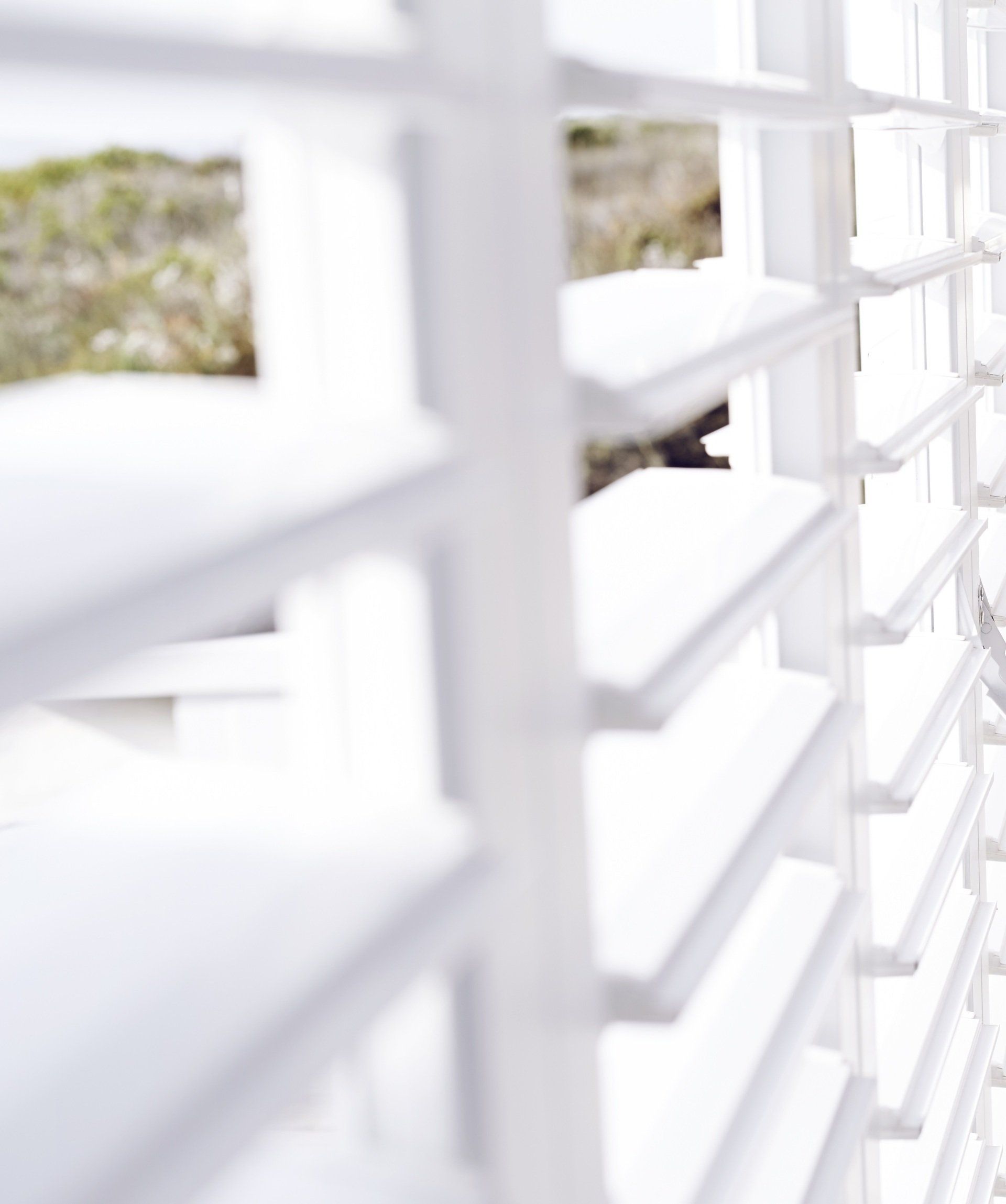 Close up view of white Plantation Shutters slightly ajar in kitchen.
