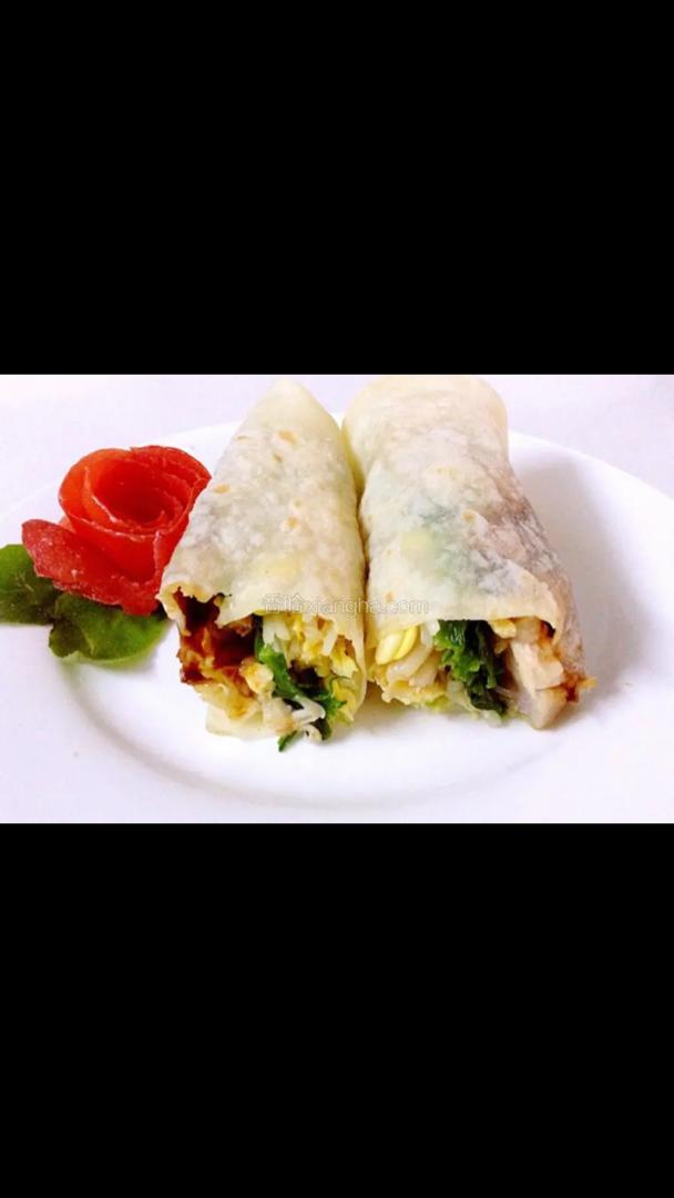 Twee wraps op een wit bord met tomaten en sla.