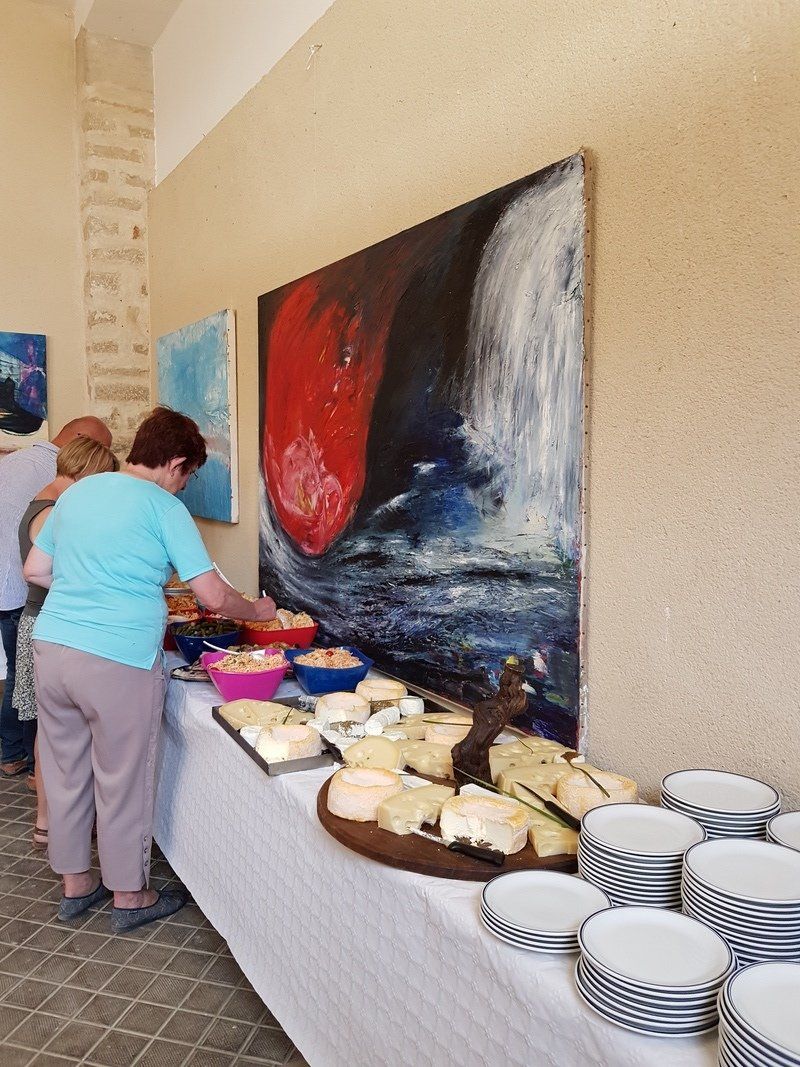 Een vrouw in een blauw shirt staat aan een buffet tafel