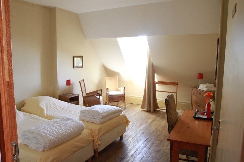 Een slaapkamer met twee bedden, een bureau en een stoel