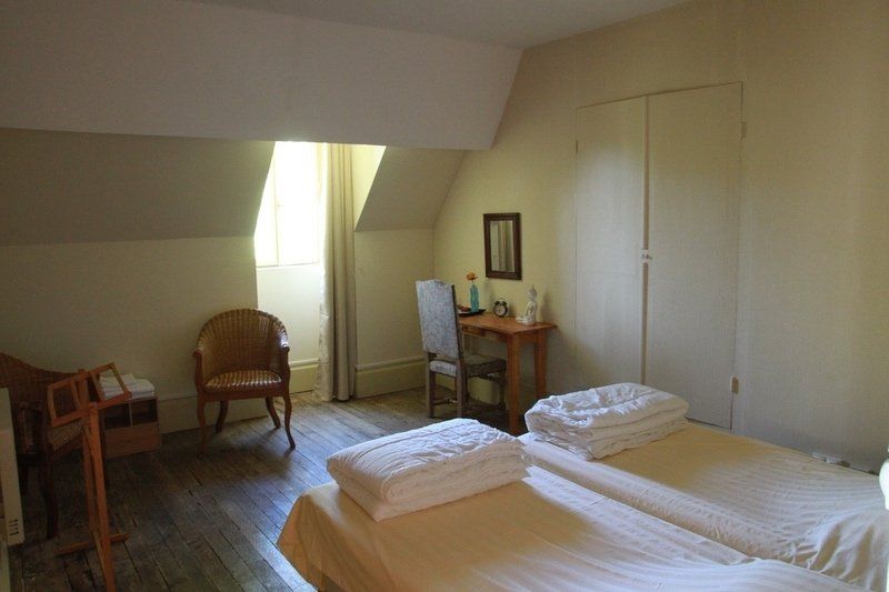 Een slaapkamer met twee bedden, een stoel en een bureau