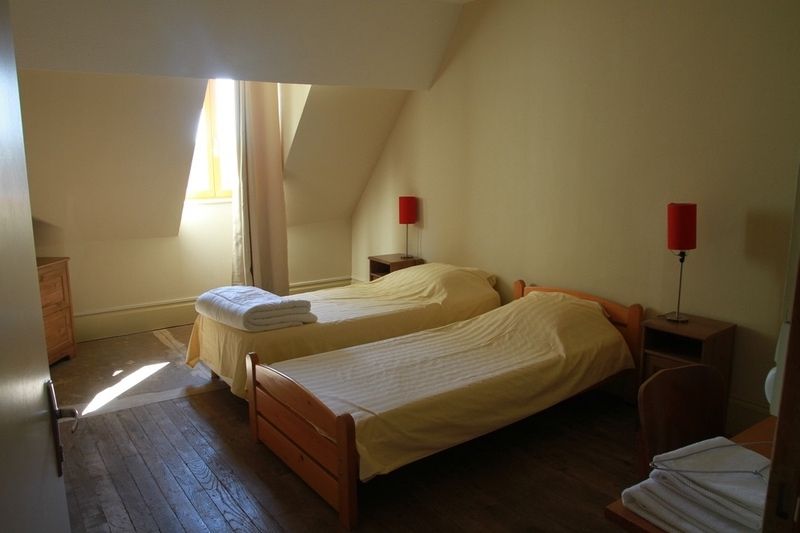 Een slaapkamer met twee bedden en twee lampen