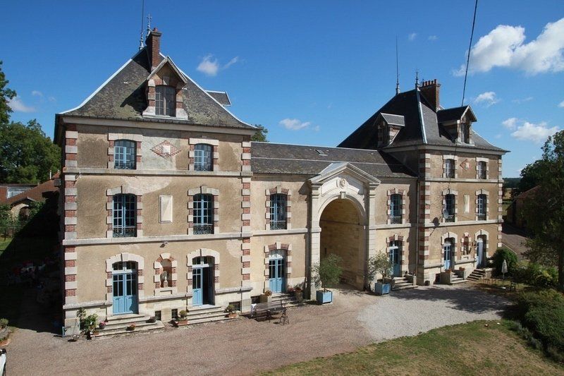 Een groot bakstenen gebouw met blauwe deuren en ramen
