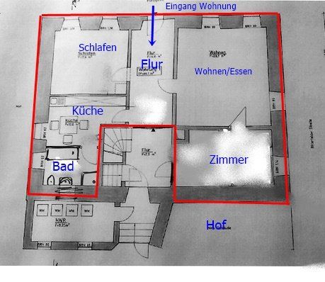 Annotated apartment floor plan with red outlines and blue labels for rooms like Schlafen, Küche, Bad, Wohnen/Essen, Zimmer.