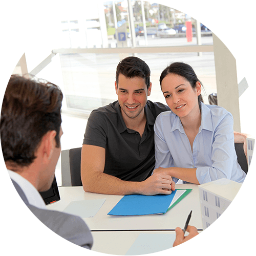 Drei Personen besprechen in einer Besprechung Dokumente an einem hellen Bürotisch.