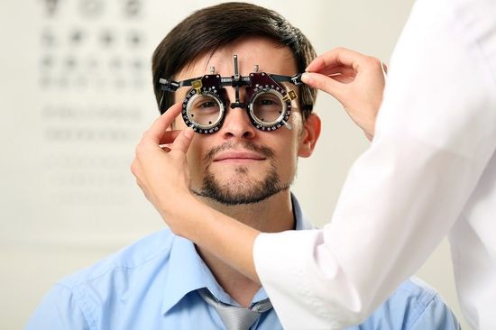 Female doctor examing adult male patient A doctor conducts comprehensive eye exams near Pottsville, AR